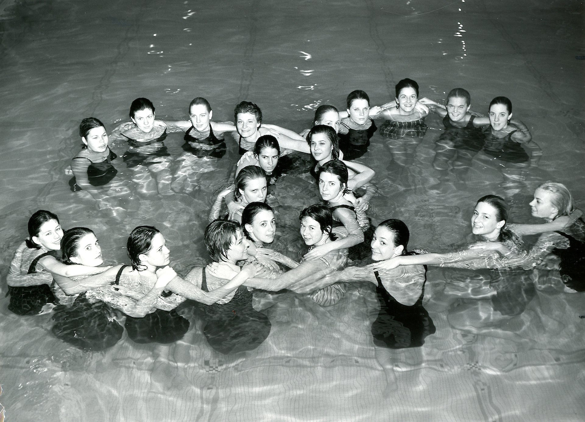 Historical image of a group of synchronized swimmers in a figure eight.